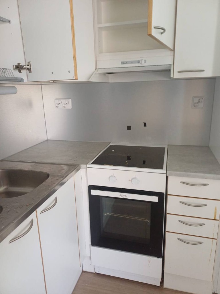 Kitchen stove and sink area before cleaning