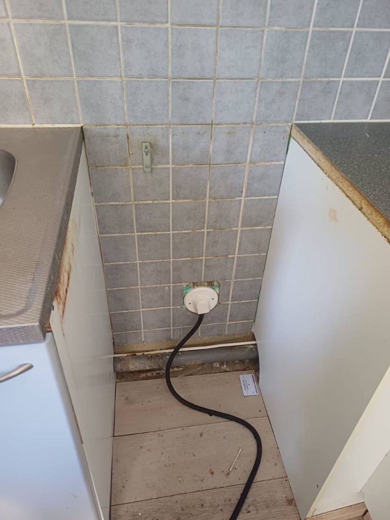 Dirty floor gap under stove before cleaning